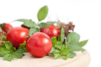 fresh red tomatoes and green parsley on white background