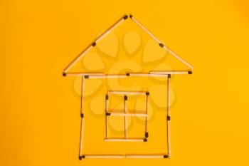 conceptual picture is not a big House of matches on a yellow background