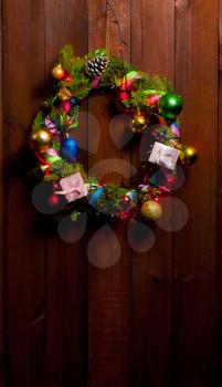 Christmas wreath decorated with toys on an old wooden brown door