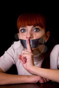 girl with her mouth sealed with tape brought finger to his mouth calling silent