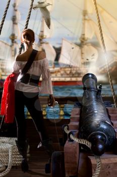 pirate captain in sexy clothes calmly stands on the deck of her ship under enemy fire and waits for an opportunity to attack
