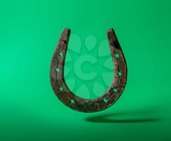 old classic horseshoe symbol of good luck over bright green background