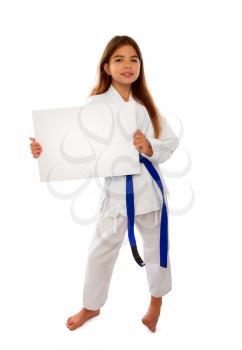 karate girl with a blue belt and a white kimono is holding a blank sheet of paper with a place for text