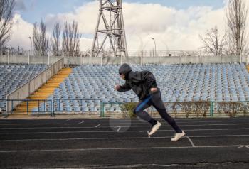 man in sportswear goes in for sports jogging through an empty stadium