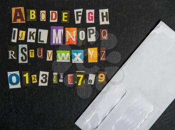 alphabet for anonymous letters cut out in separate letters from different newspapers on a dark background