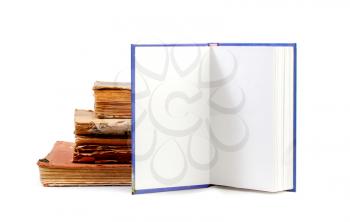 New open book with empty blank pages next to a stack of old books isolated on white background