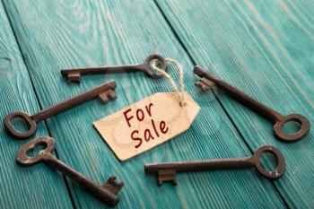 real estate sale concept - old key with tag