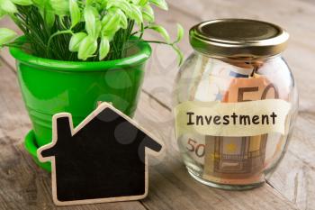 Real estate finance concept - money glass with Investment word