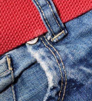 Macro shoot of jeans pocket and red belt.