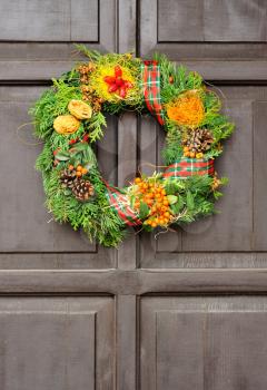 Nice Christmas wreath hanged on the wood door.