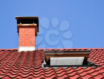 Red roof with chimney made from tiles and one dormer.