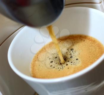 Closeup shot of an hot fresh espresso pouring to the cup  in espresso machine.