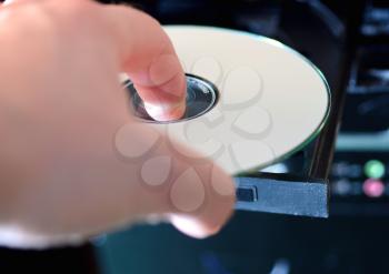 Hand puts the CD to the audio player.