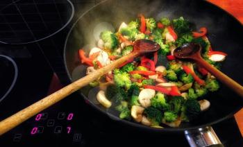 Cooking the Vegetable Chicken Stir Fry in Wok Pan with Two Stirring Spoon.