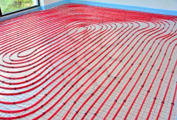 Water underfloor heating pipes on the silver reflective foil in house construction.