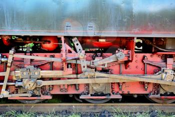Old steam locomotive iron wheels as background.