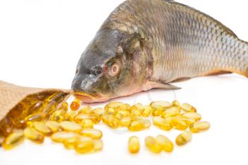 Omega 3 capsules and fresh fish isolated on a white background