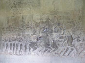 The bas-relief of soldiers on horseback with the walls of the temple at Ankor Wat