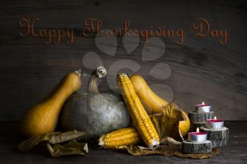 Happy Thanksgiving Day, Decoration on a wooden table with Pumpkins, Corncob, Burning Candles and autumn leaves
