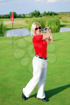 Happy blonde girl playing golf