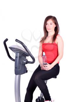 girl with bottle of water sitting on cross trainer