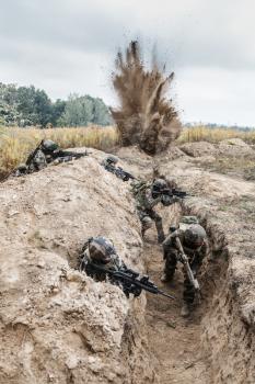 Squad of elite french paratroopers of 1st Marine Infantry Parachute Regiment RPIMA in action in enemy trenches, militants and machine gunner