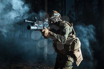 Image of soldier in the smoke moving in battle operation. Back light, cropped, toned and colorized