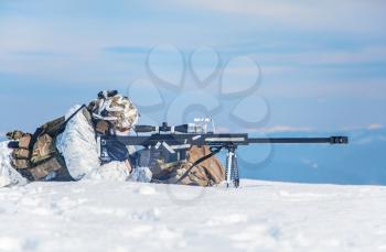 Army soldier with Sniper rifle in action in the Arctic. He lies in the snow desert, suffering from extreme cold, but waiting as long as enemies appear to kill them