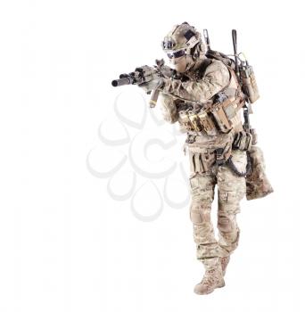 Army infantryman in camouflage uniform, battle helmet, tactical radio headset, extra ammo on load carrier, sneaking, aiming with laser sight on assault rifle studio shoot isolated on white background