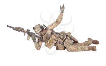 Modern army soldier, infantry rifleman equipped with tactical ammunition and radio, lying on ground, observing territory trough optical sight, aiming, shooting with assault rifle isolated studio shoot