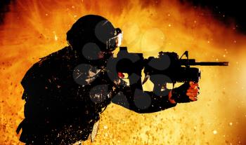 Special forces fighter, counter terrorist team shooter aiming assault rifle with grenade launcher, shooting in firefight, breaking through fire on battlefield, rushing on enemies, attacking targets