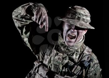 Commando soldier, elite forces fighter, special operations troops infantry in camo uniform, pointing finger down, yelling with anger, screaming order, showing attention direction, low key portrait