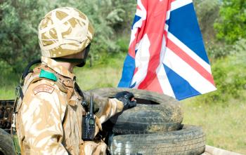 british soldier with the UK flag at the checkpoint
