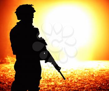 Black silhouette of soldier on the nuclear explosion background. Back light, cropped, toned and colorized