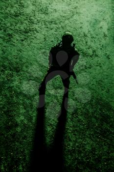 Black silhouette of soldier at night. View from above, toned and colorized
