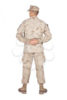 Full length rear view studio shoot or army soldier in camouflage uniform and utility cover, standing in parade rest position with legs on shoulder width and hands behind back isolated on white