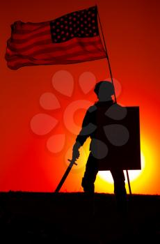 Silhouette of American army soldier armed sword and shield standing under waving US national flag on background of sunset. Army hero and patriot, military glory and honor, fallen soldiers remembrance