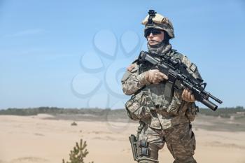 Portrait of United states airborne infantry corporal with arms, camo uniforms dress. Combat helmet on, half lengh portrait