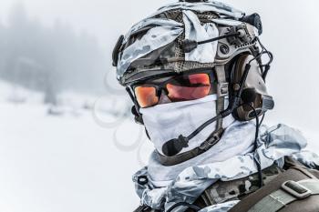 Winter arctic mountains warfare. Action in cold conditions. Trooper with weapons in forest somewhere above the Arctic Circle