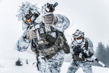 Winter arctic mountains warfare. Action in cold conditions. Pair of special forces weapons in forest somewhere above the Arctic Circle, low angle view