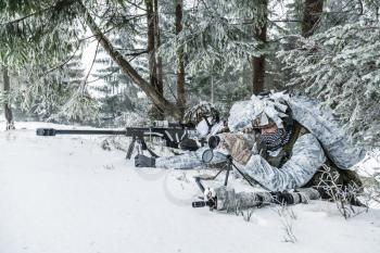 Winter arctic mountains warfare. Action in cold conditions. Sniper and spotter with weapons in wait somewhere above the Arctic circle