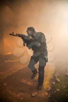 Special forces operator in black uniform in the smoke