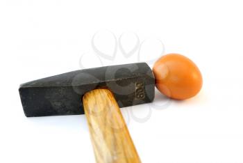 Small egg under a heavy hammer on a white background.