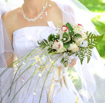 Beautiful white wedding bouquet in hands of the bride.
