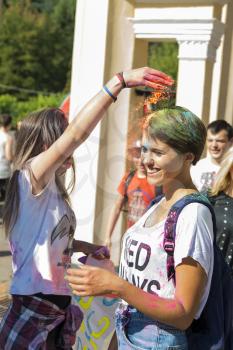 Lviv, Ukraine - August 30, 2015: Girls sprinkled each other with paint during the festival of color in a city park in Lviv.