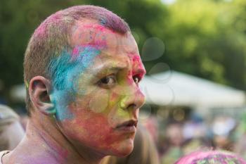 Lviv, Ukraine - August 30, 2015: Man watches festival of colors in a city park in Lviv.