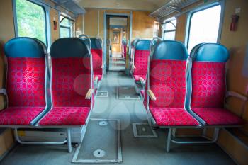 Interior of a modern train with windows and empty red seats