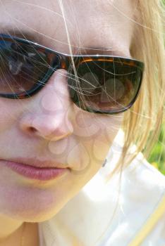 Pretty young blond woman in sunglasses. Closeup shot