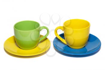 Colored teacups and saucers isolated on white.