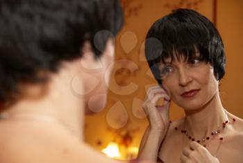 Portrait of a beautiful young woman near mirror